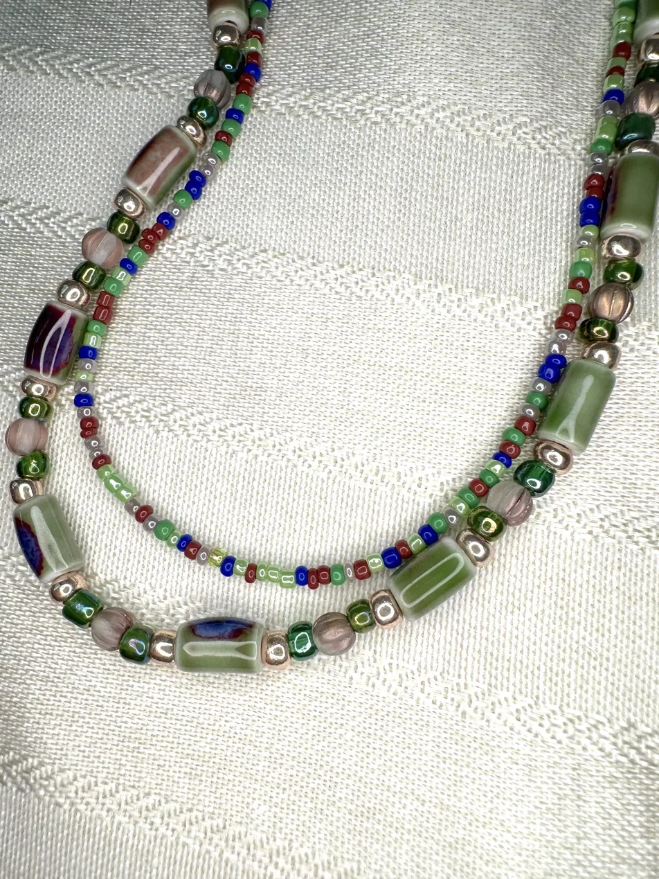 Handmade double-strand layered necklace featuring green, blue, and copper-toned glass beads — part of the Moss Light collection. Hand-strung with hypoallergenic hardware.