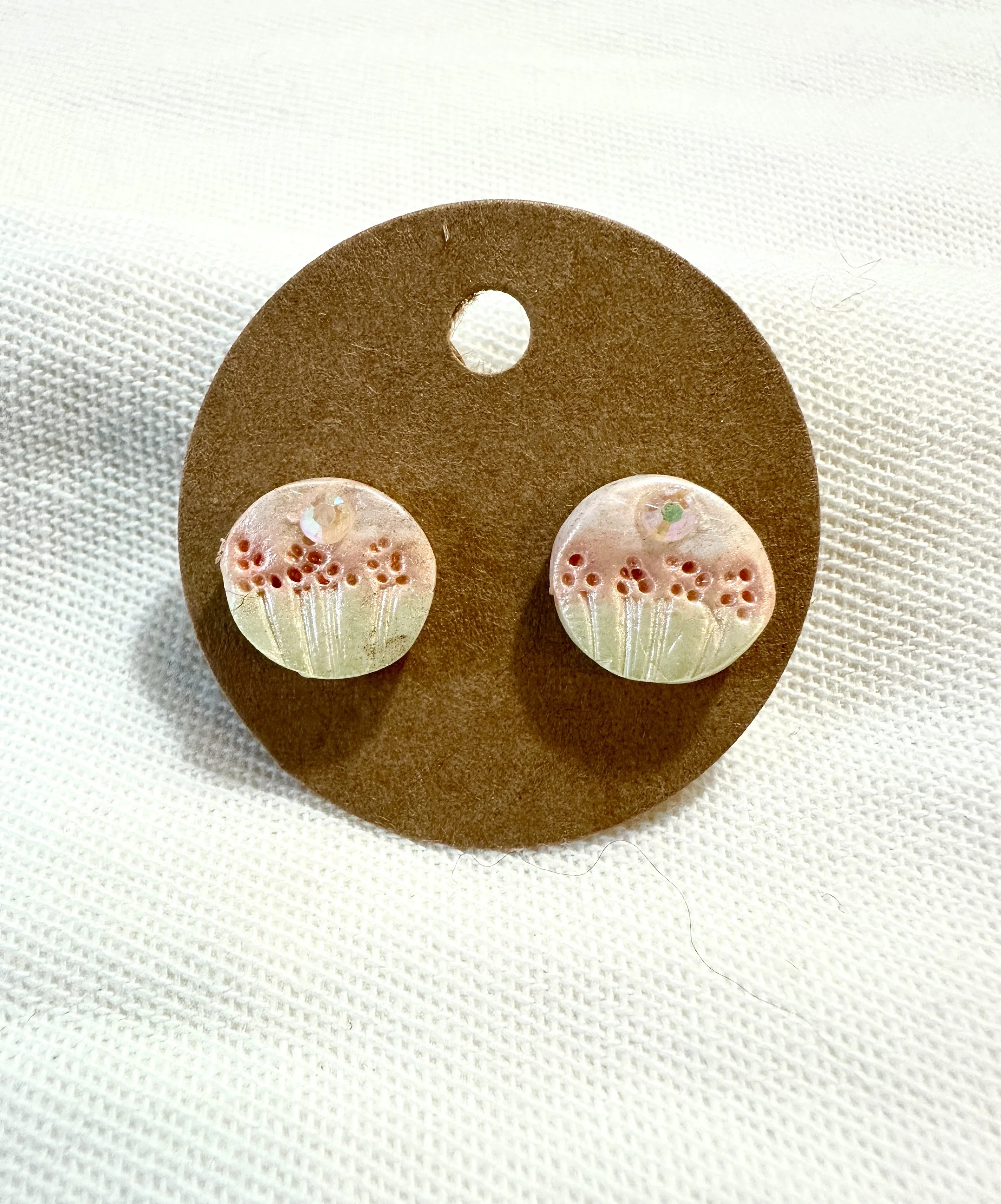 Handmade sculpted stud earrings featuring a hand-painted meadow design in cream, red, and green with an iridescent rhinestone accent — part of the Peony collection. Hypoallergenic earring posts.