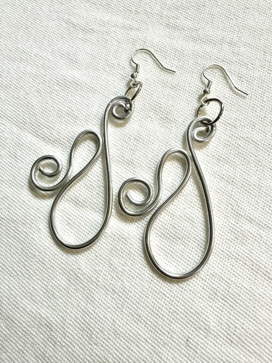 Handmade signature earrings featuring a hand-formed silver wire spiral design — part of the Silver tone collection. Hypoallergenic ear wires, wire-sculpted by hand.
