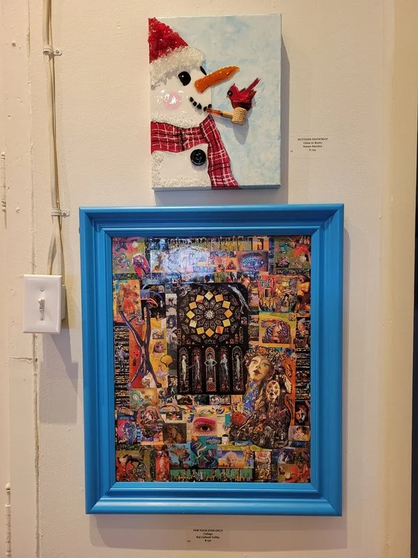 A snowman craft with a red hat, a carrot nose, a red and white checkered scarf, and a pipe, hanging on the wall above a blue picture frame containing a collage of various colorful images.