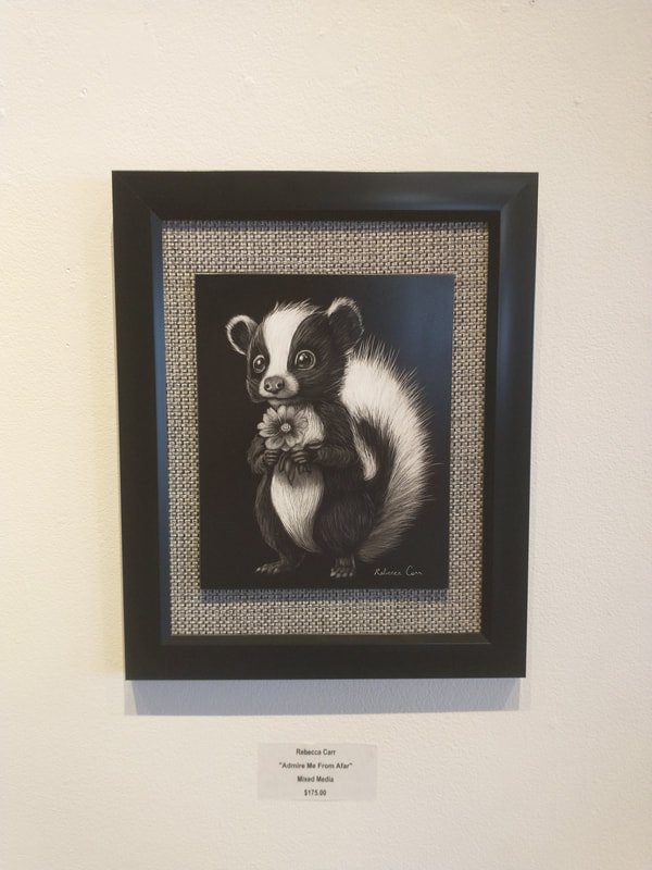Black and white framed artwork of a cute cartoon-style ferret holding a flower, displayed on a white wall.