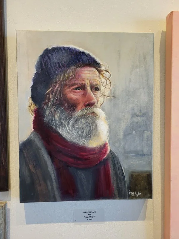 A painting of an older man with a gray beard, wearing a dark beanie, a red scarf, and a dark jacket, looking into the distance.