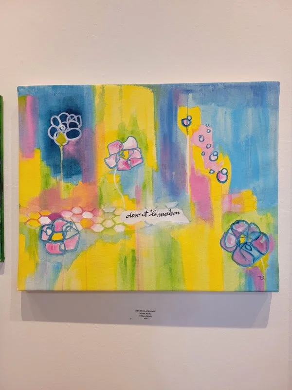 Abstract colorful painting with flowers and honeycomb patterns, featuring pastel shades of pink, blue, yellow, green, and purple, with a handwritten message in the center that reads 'devant la maison'.