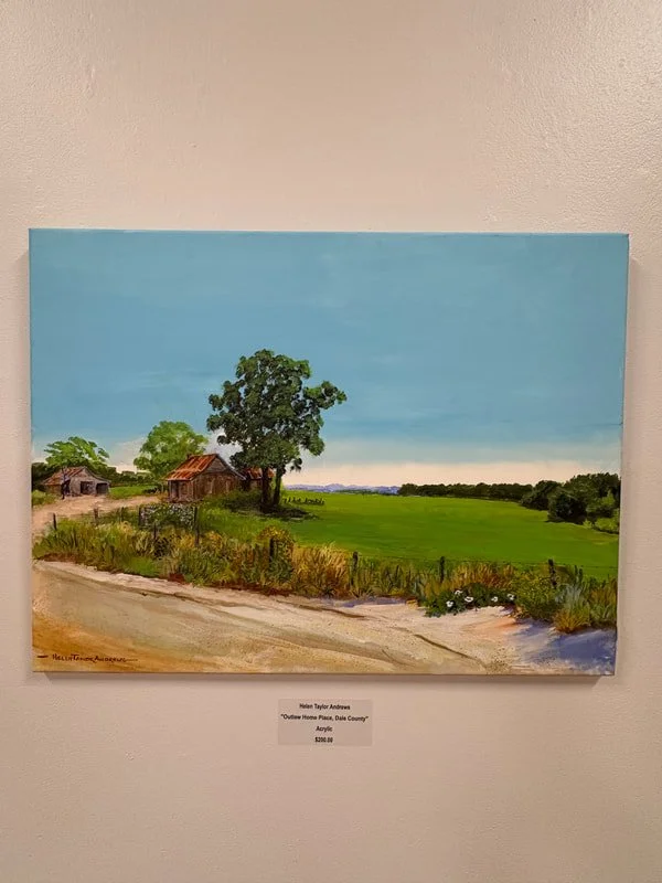 Painting of a rural landscape with a dirt road, a large tree, small barns or houses, green fields, and a blue sky.