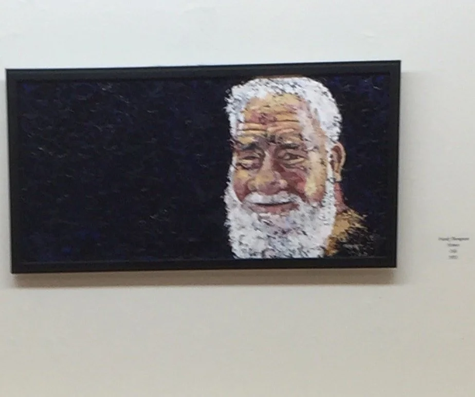Pixelated digital portrait of an elderly man with a white beard and white hair, smiling against a dark background.