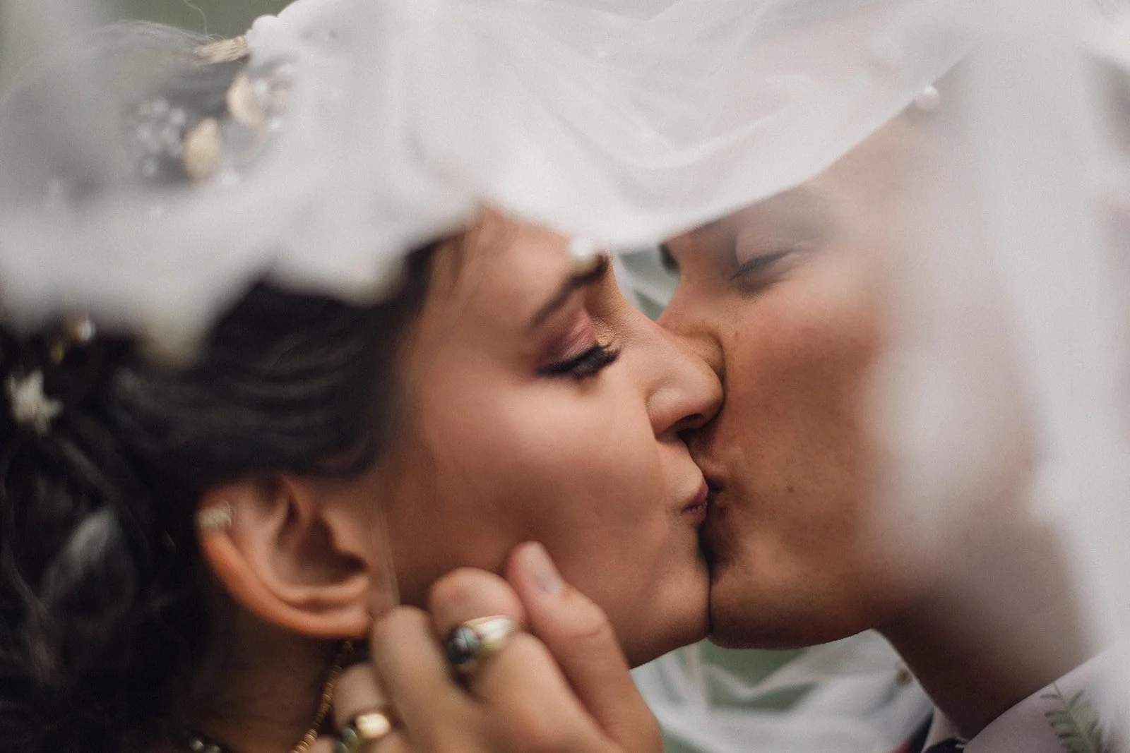 a close up of a bride and groom kissing under her veil-polaroid