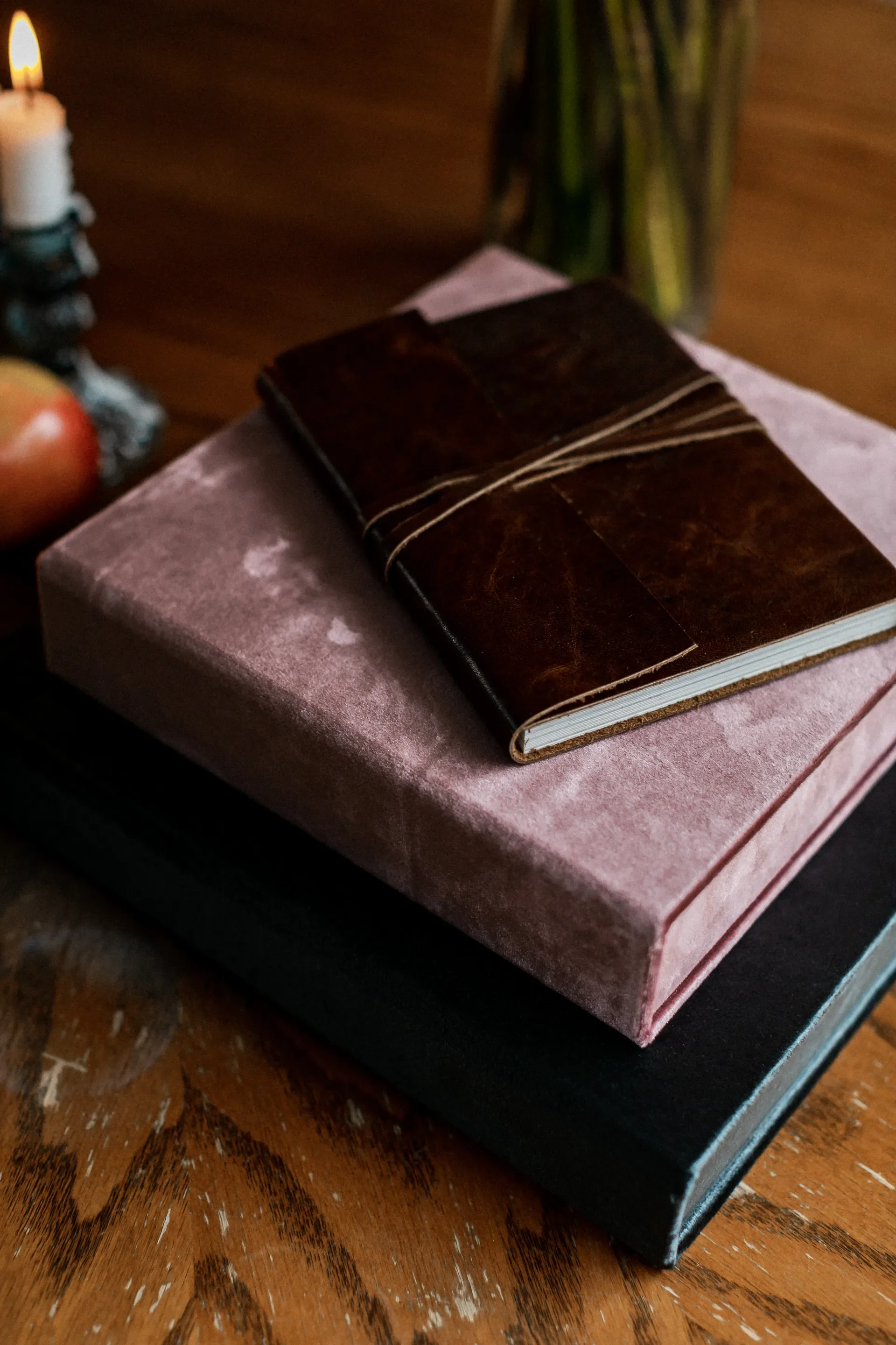 Teal and blush velvet wedding albums arranged in a flat lay from above