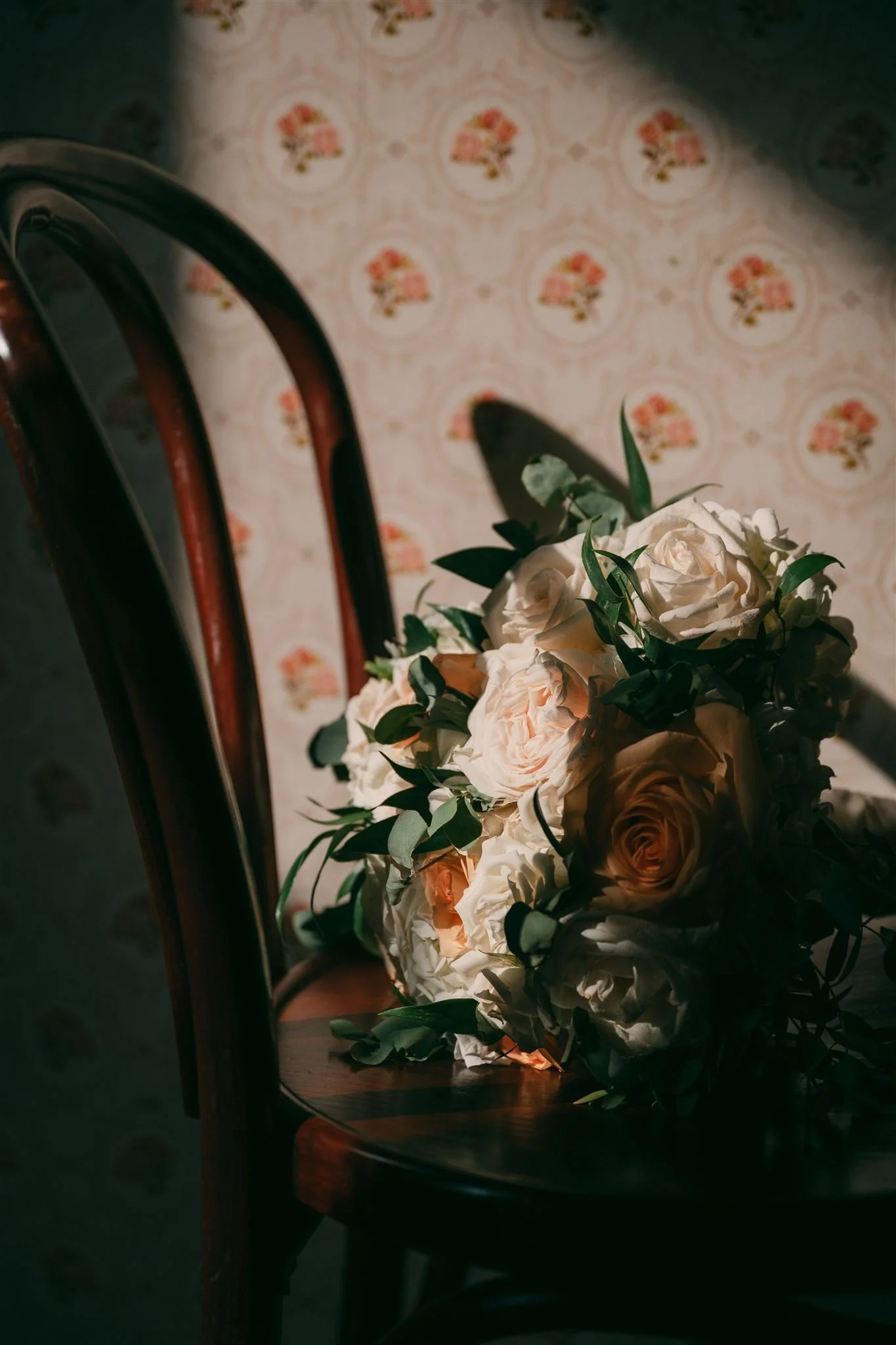 A bridal bouquet sitting on a wooden chair