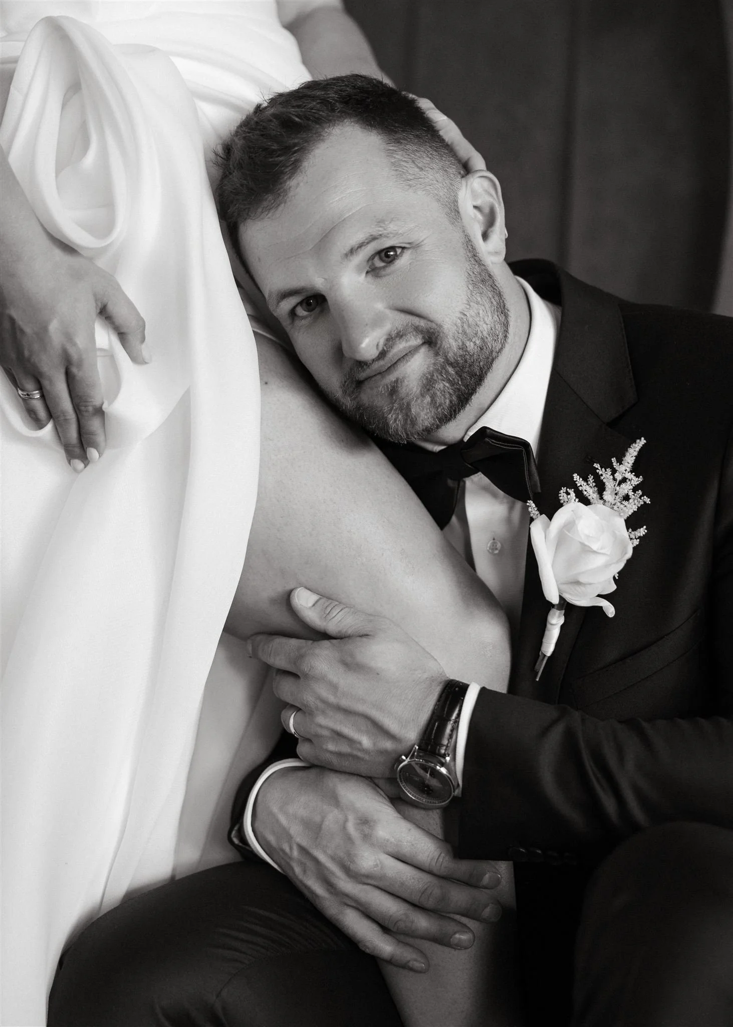 a portrait of a groom holding his bride's leg