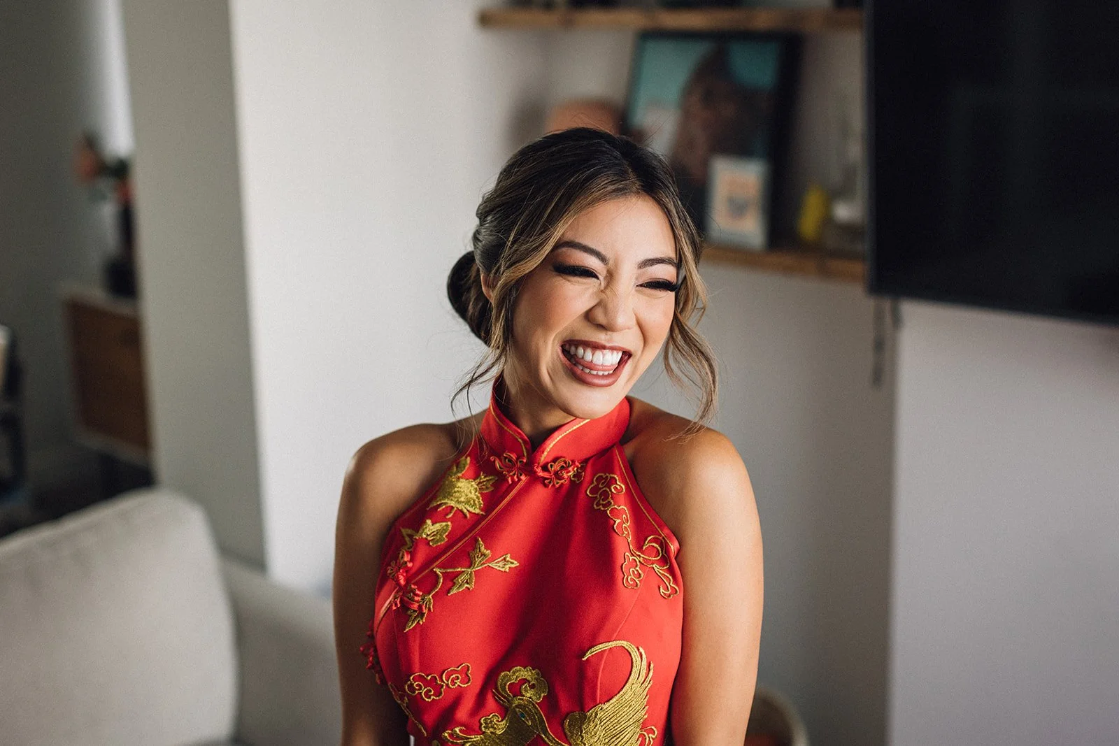A bride beams as she's put on her traditional red Eastern wedding dress