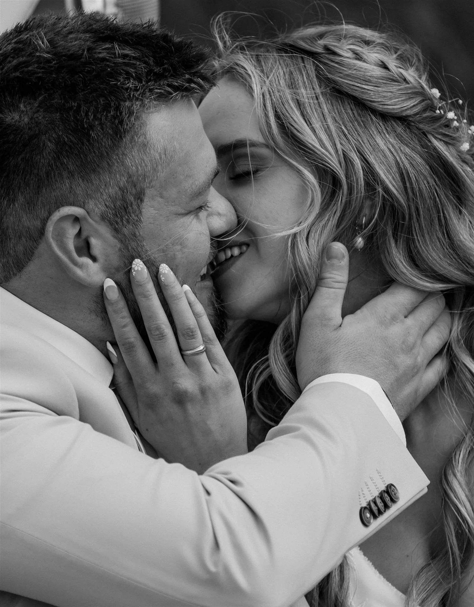 close up photo of a bride and groom smiling and about to kiss