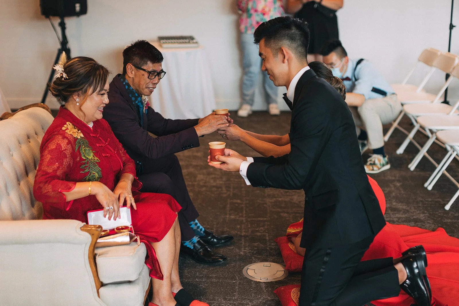 A couple exchanges cups with relatives during a tea ceremony