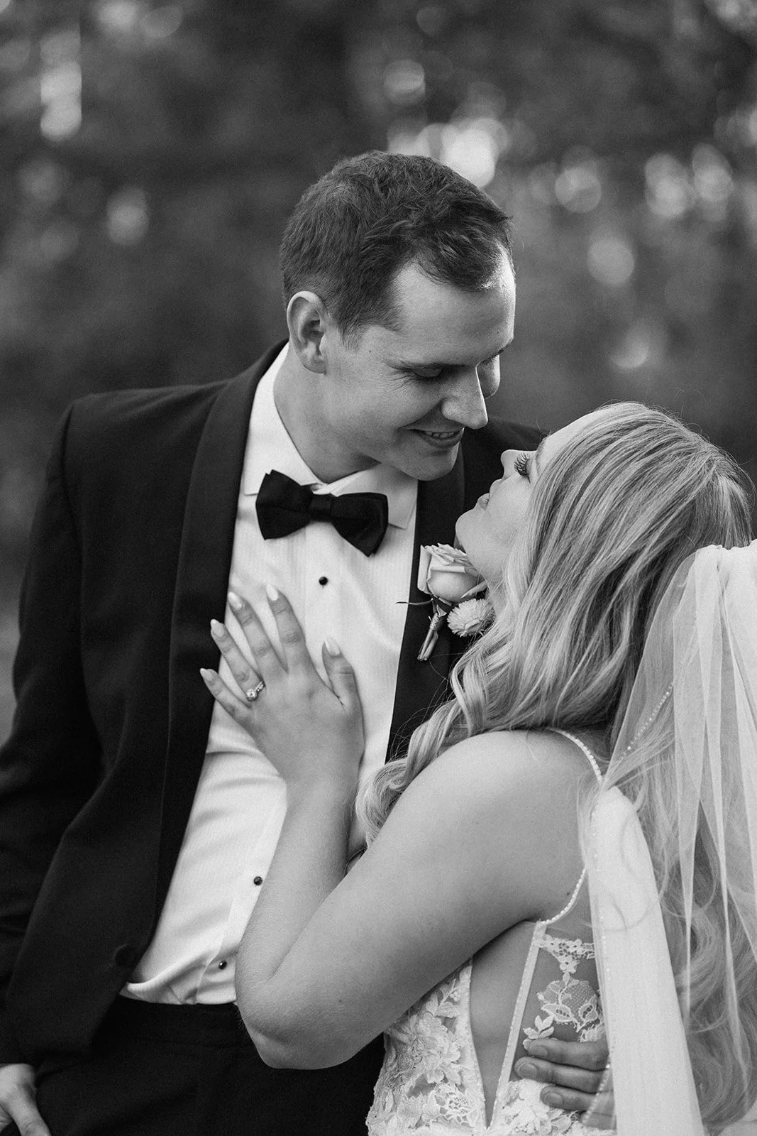black and white wedding portrait of a bride and groom looking into each others' eyes and smiling