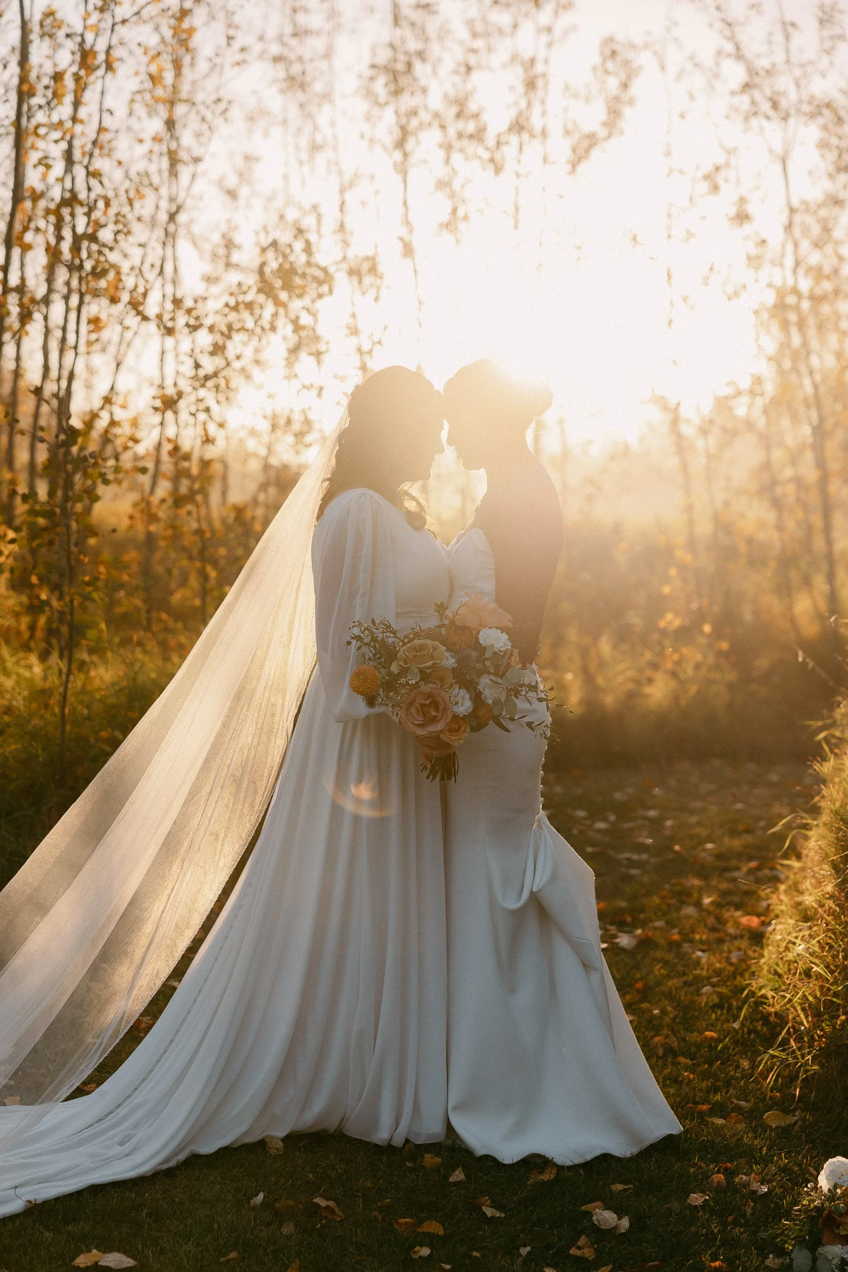 golden hour photo of two brides in a forest embracing-thin-bordered