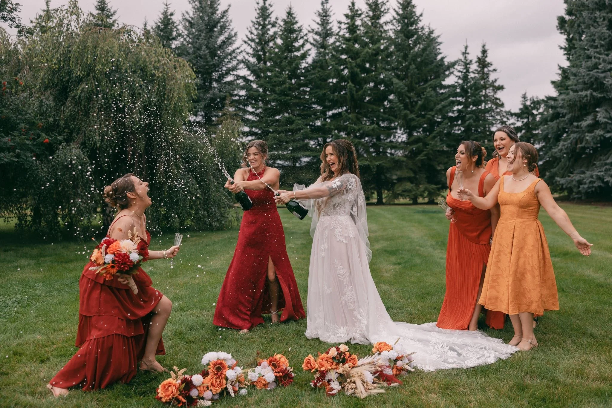 bridesmaids being silly and spraying champagne thin-bordered