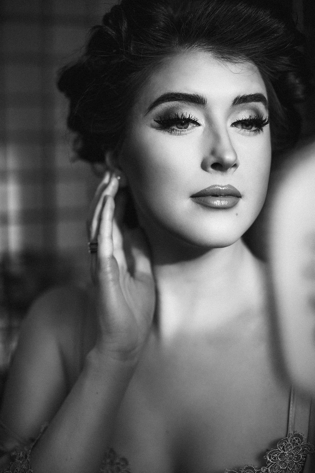 A black and white woman using a handheld mirror to lightly touch up her hair
