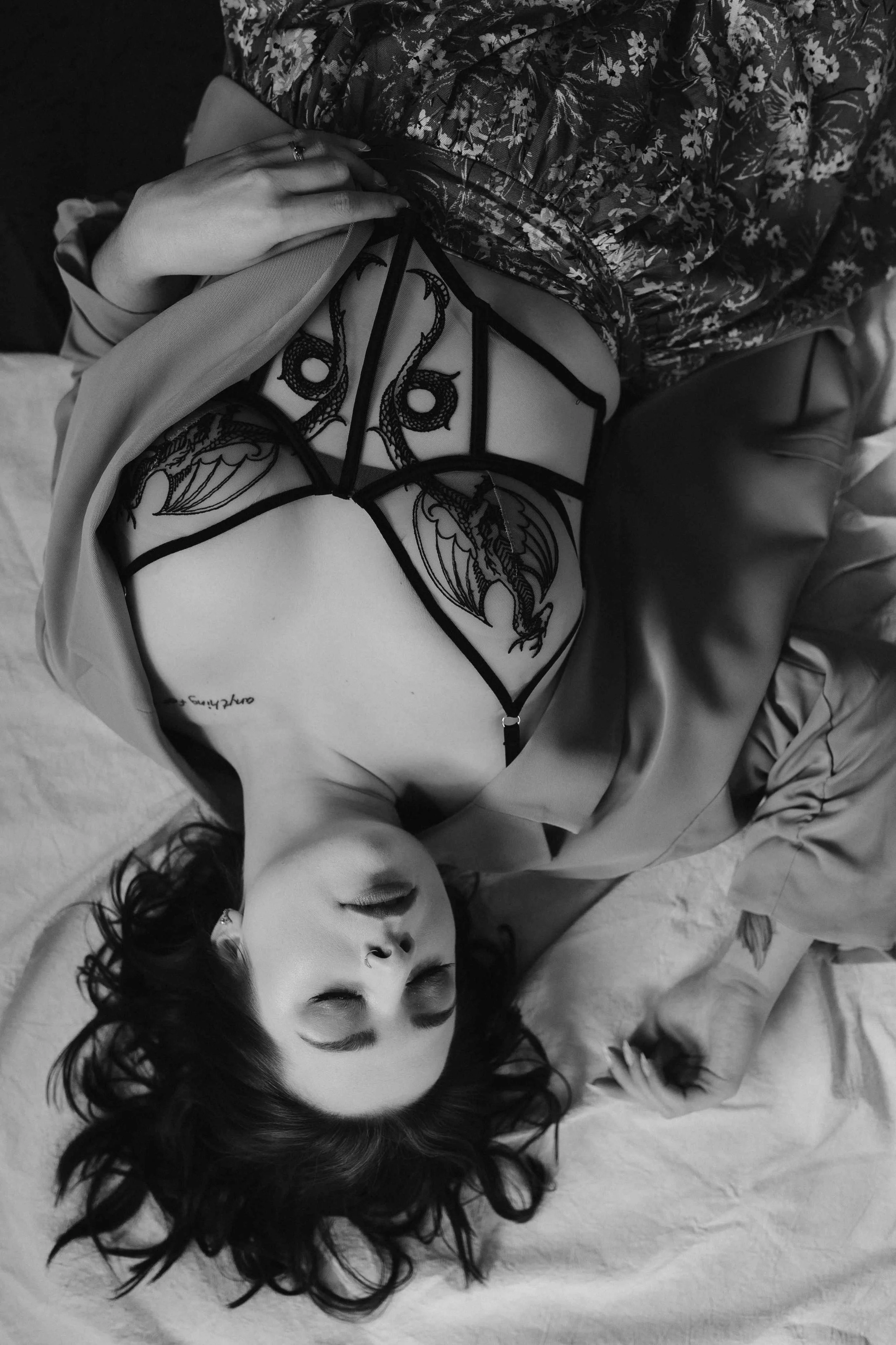 black and white photo shot overhead of a woman lying down with her eyes closed-thin-bordered