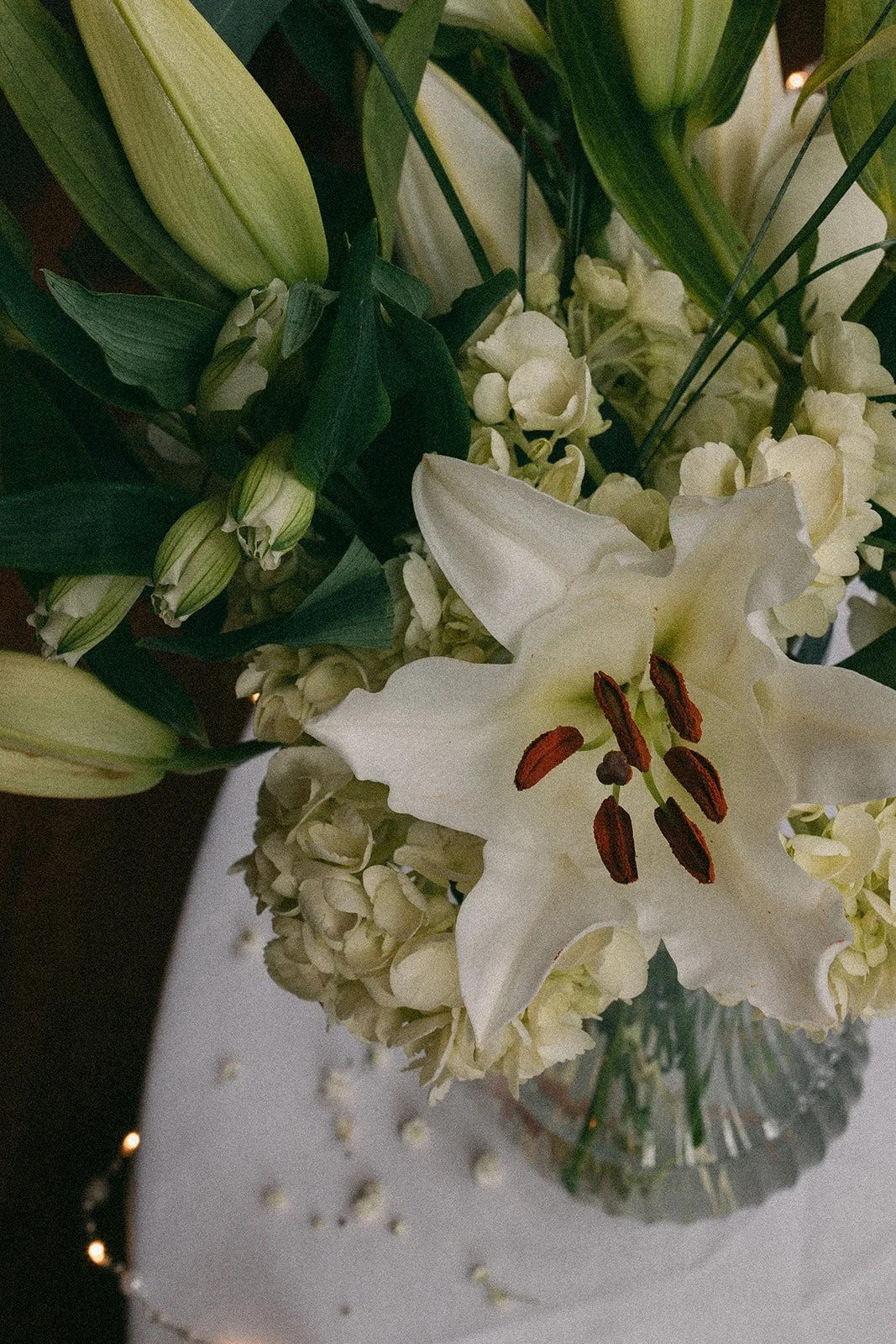 close up shot of a vase of white and green wedding flowers-thin-bordered