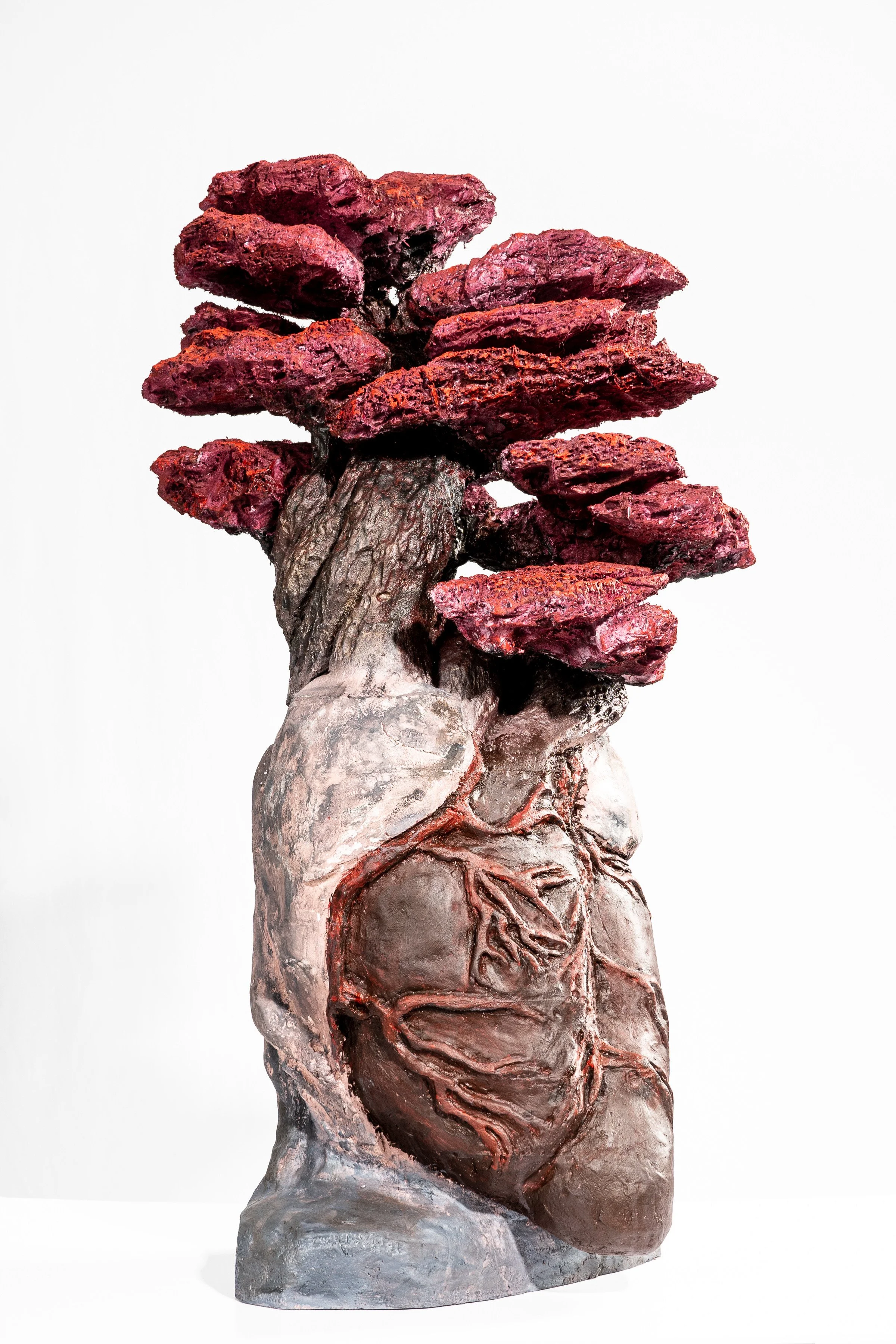 A sculpture of a human heart with tree-like structures growing from the top, resembling branches or leaves.