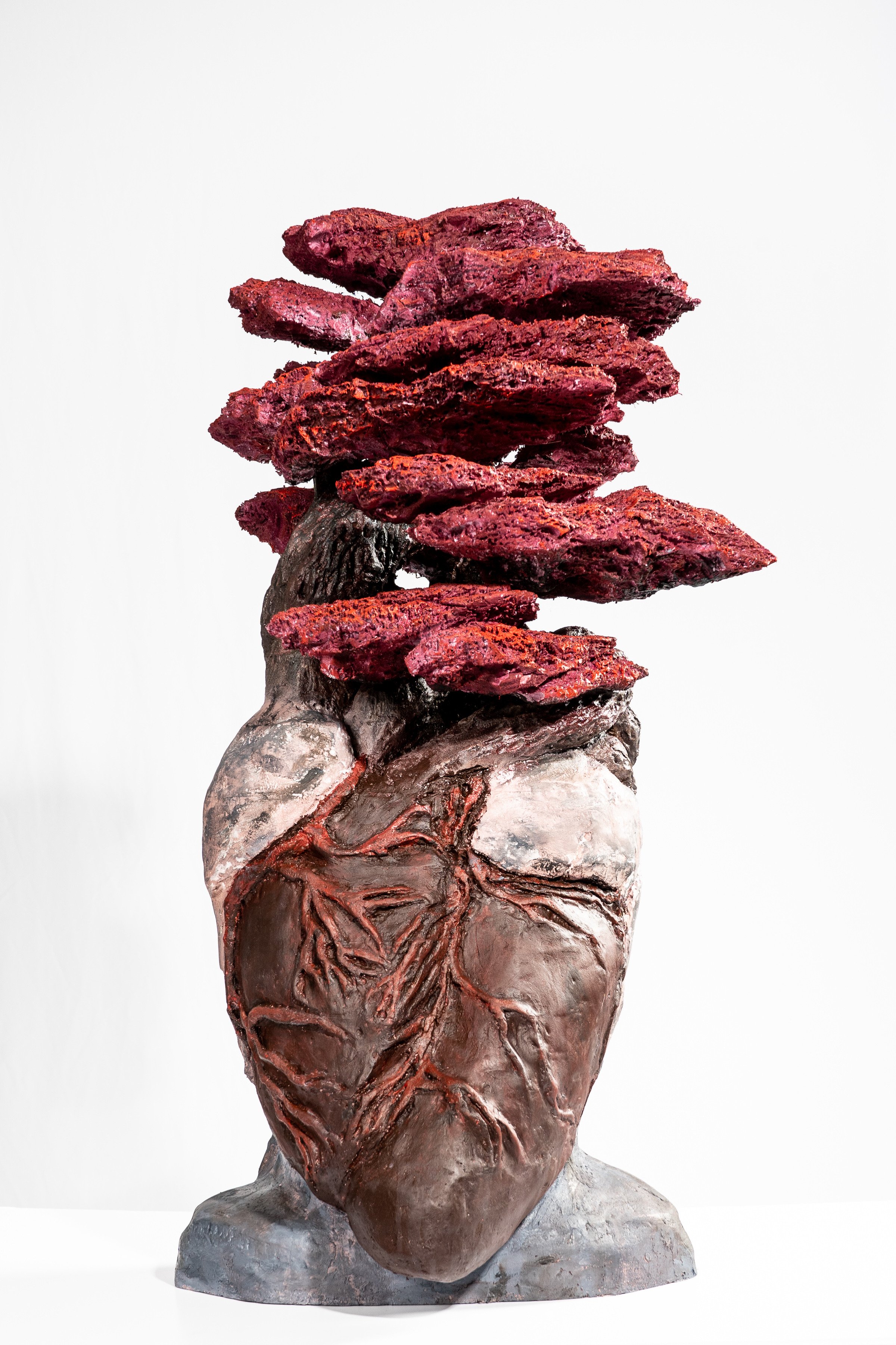 Art sculpture of a human heart with rocks balanced on top, resembling a stack of stones.