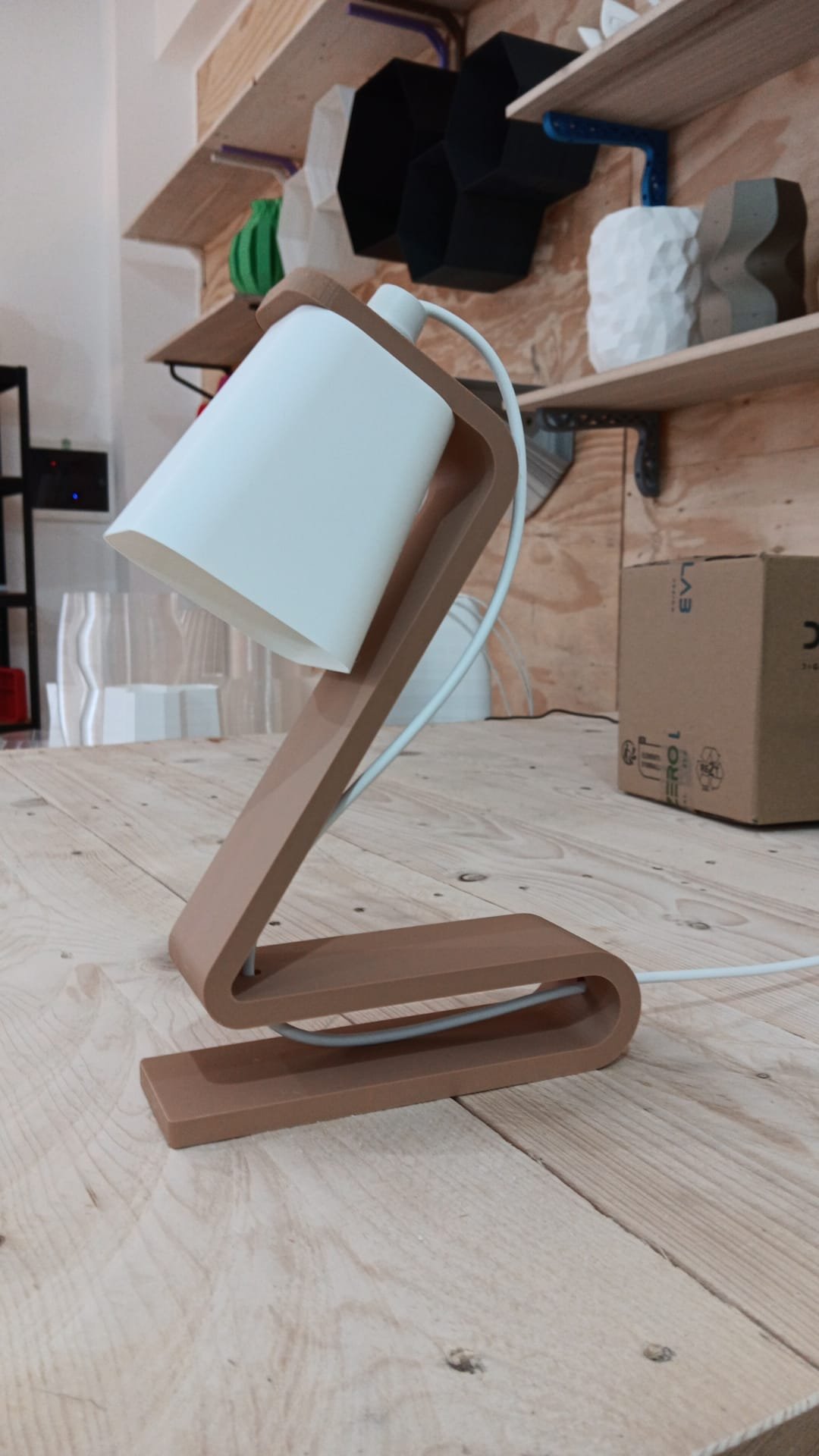 Lampada da tavolo moderna con base in legno e paralume bianco su superficie in legno.