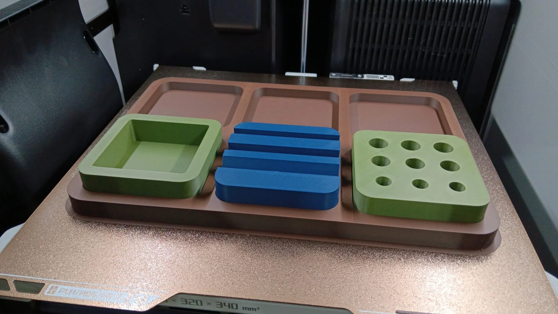 Disposto su una superficie di una bilancia elettronica ci sono diversi contenitori di forme e colori diversi, con alcuni di colore verde, alcuni blu e altri rosa.