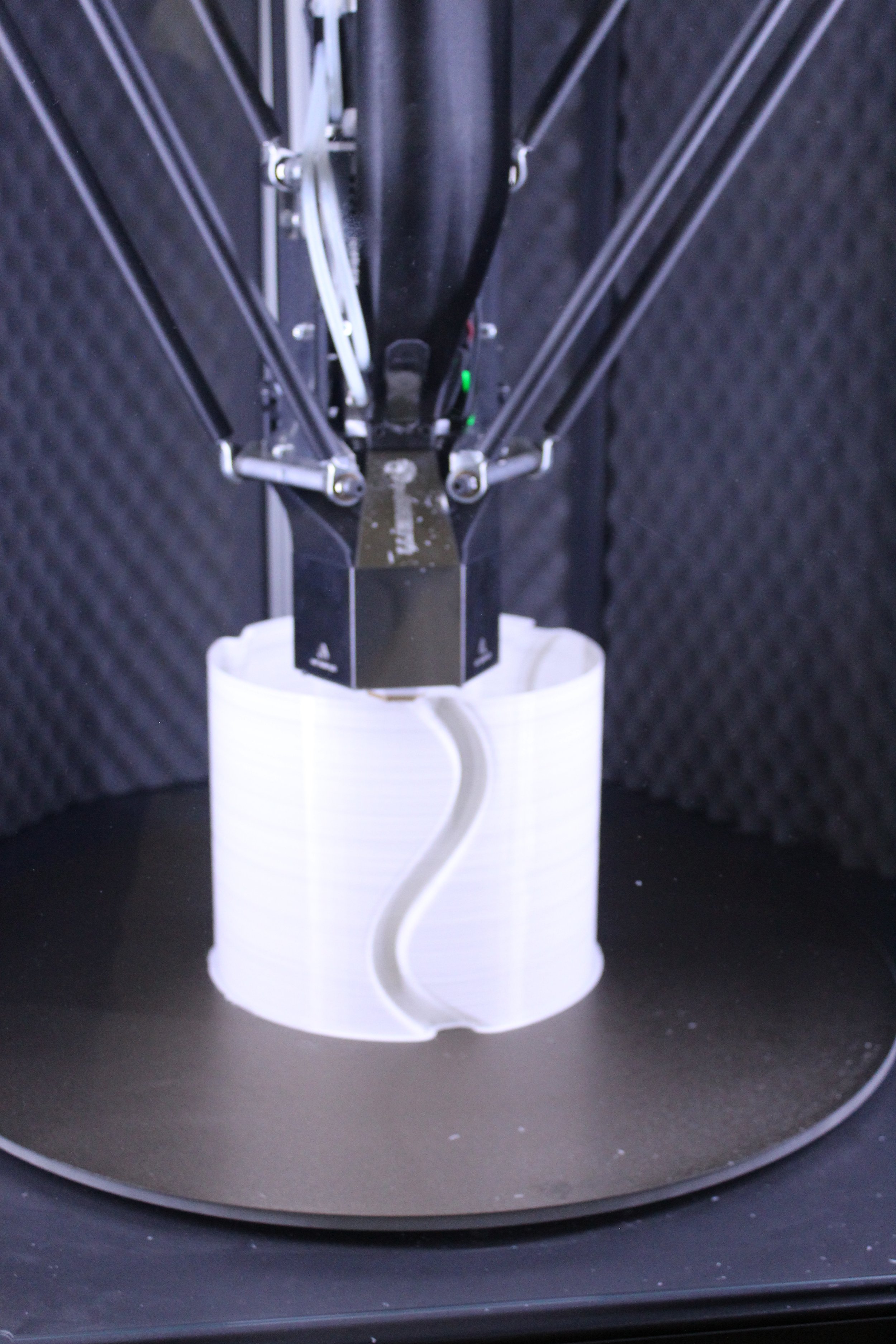 Una stampante 3D in azione che stampa un oggetto bianco 3D con un modello a forma di onda