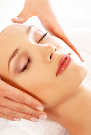 Woman receiving a facial massage with closed eyes.
