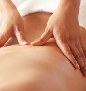 A person receiving a massage on their bare back in a spa setting.