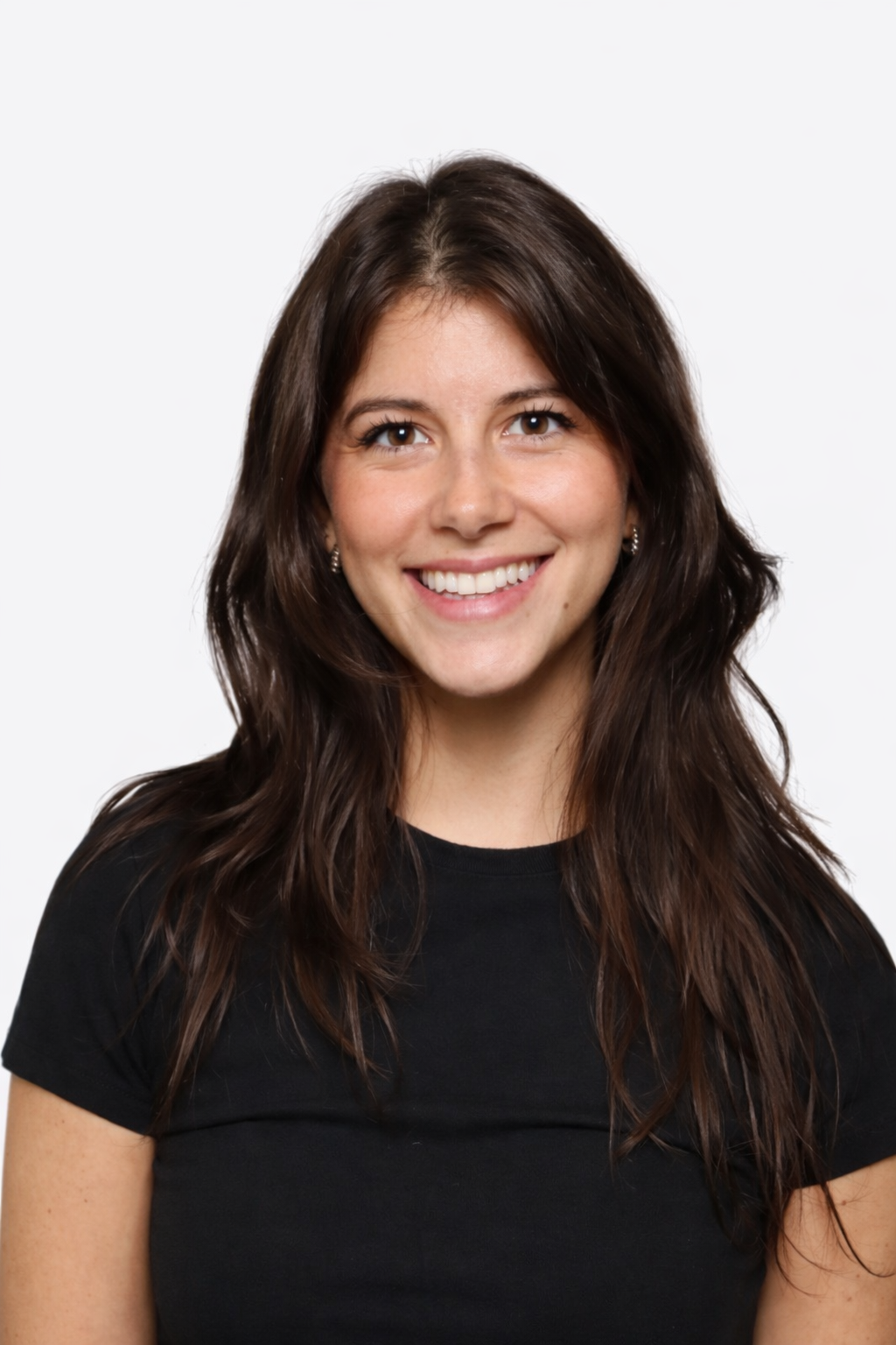 A young woman with long, wavy brown hair, smiling against a white background, wearing a black t-shirt.