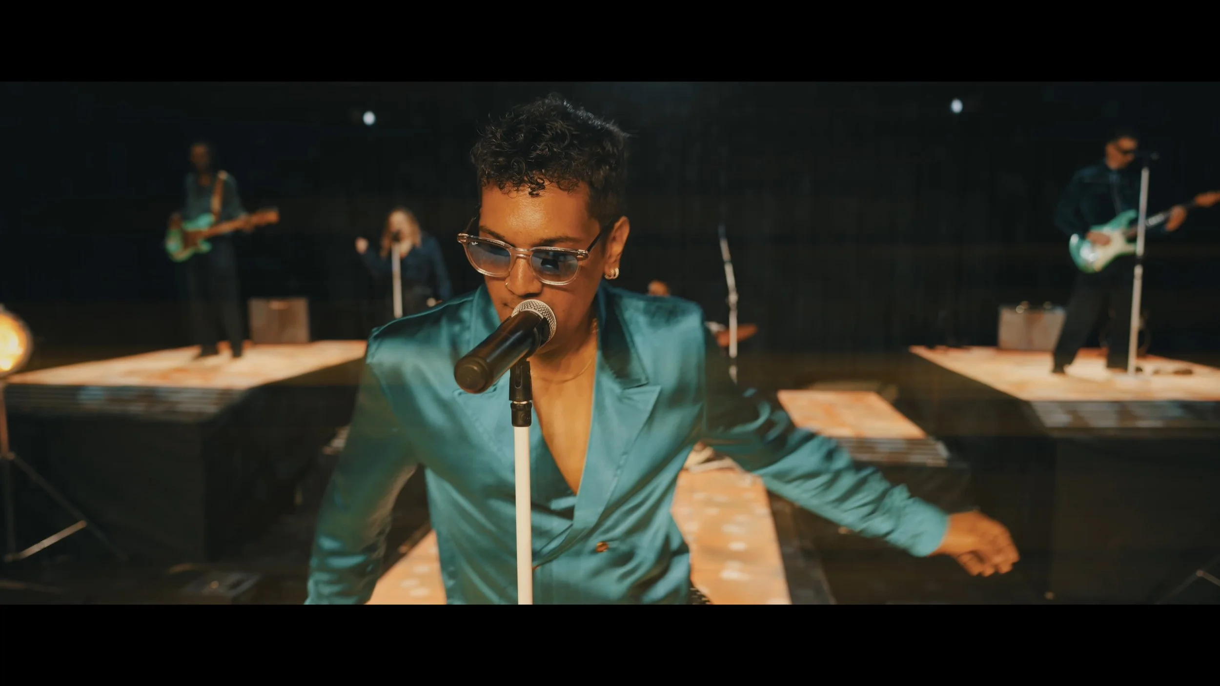 NuTown lead singer performing live with band in the background.