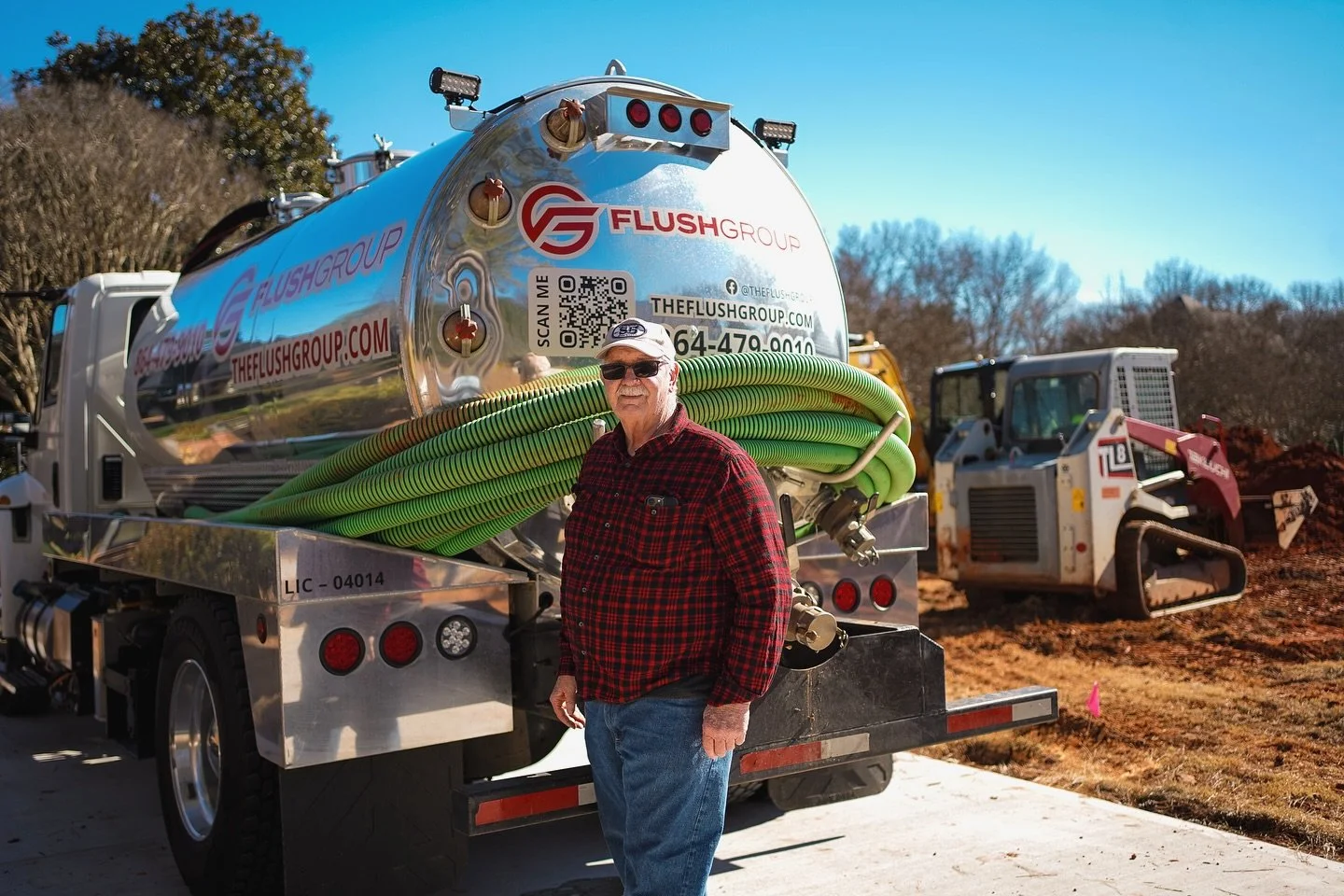 Tech standing in front of Flush Group septic service truck in South Carolina