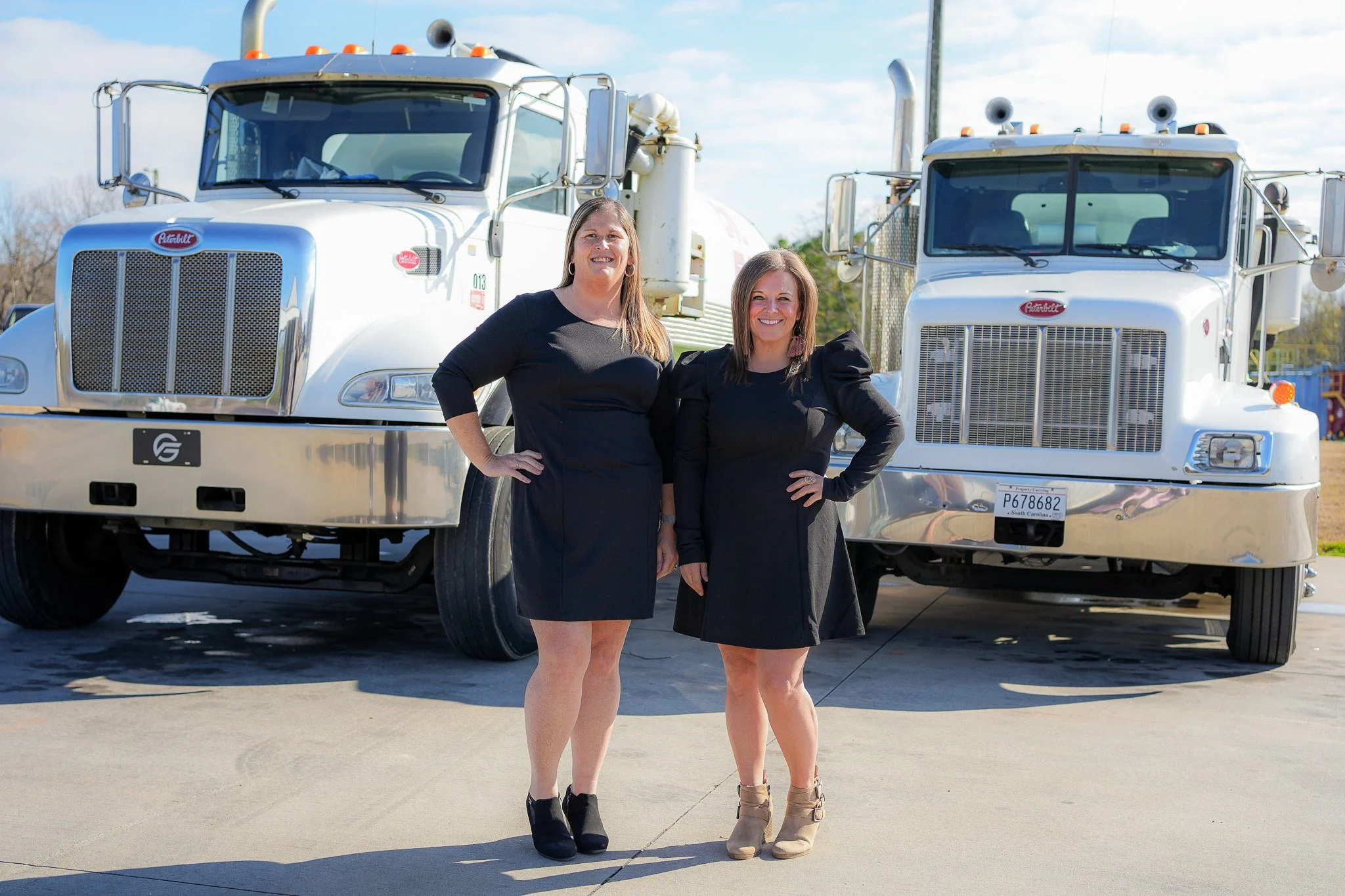 Flush Group office team members standing between commercial septic service trucks in South Carolina