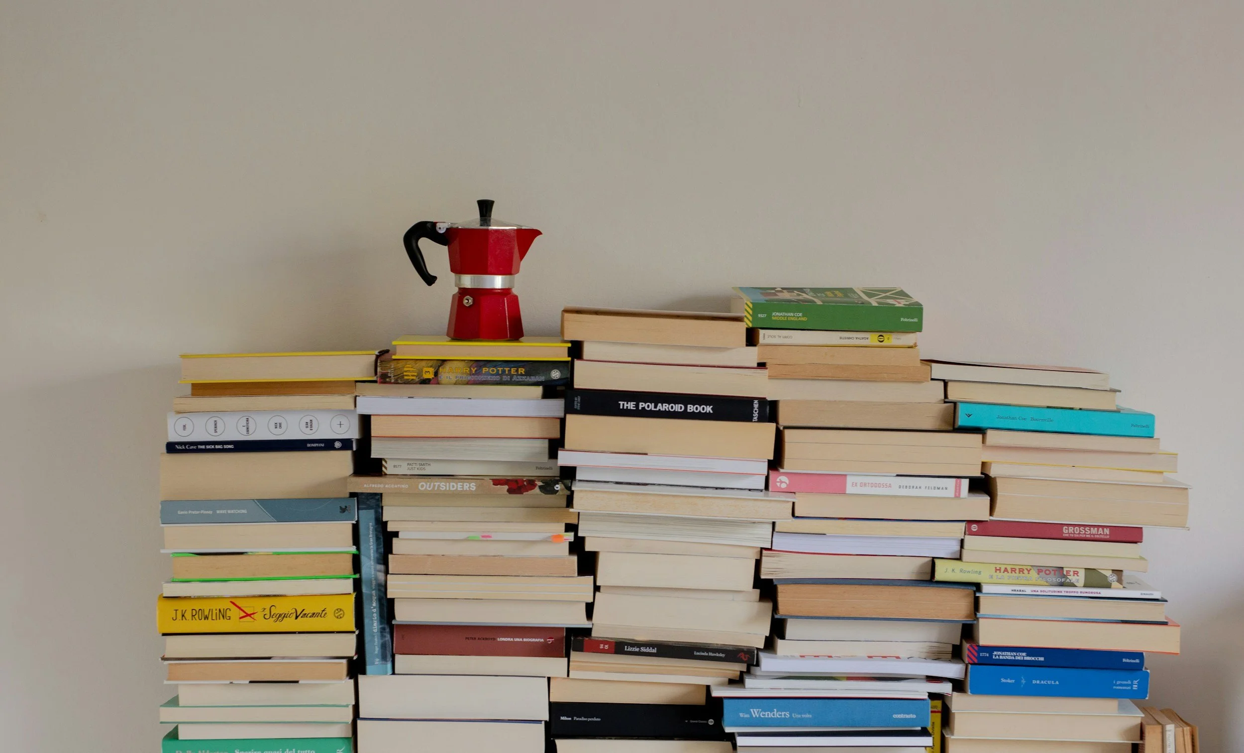 Stacks of books with a mokka espresso pot on top.