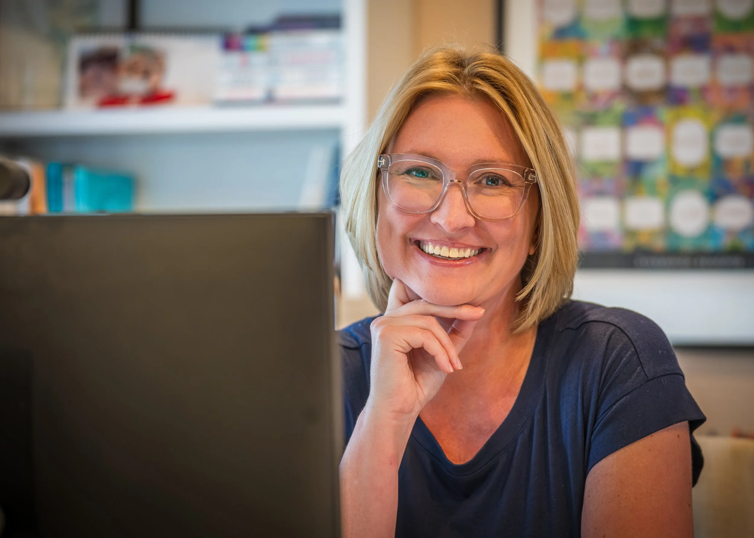 woman at desk, short blonde hair and glasses
