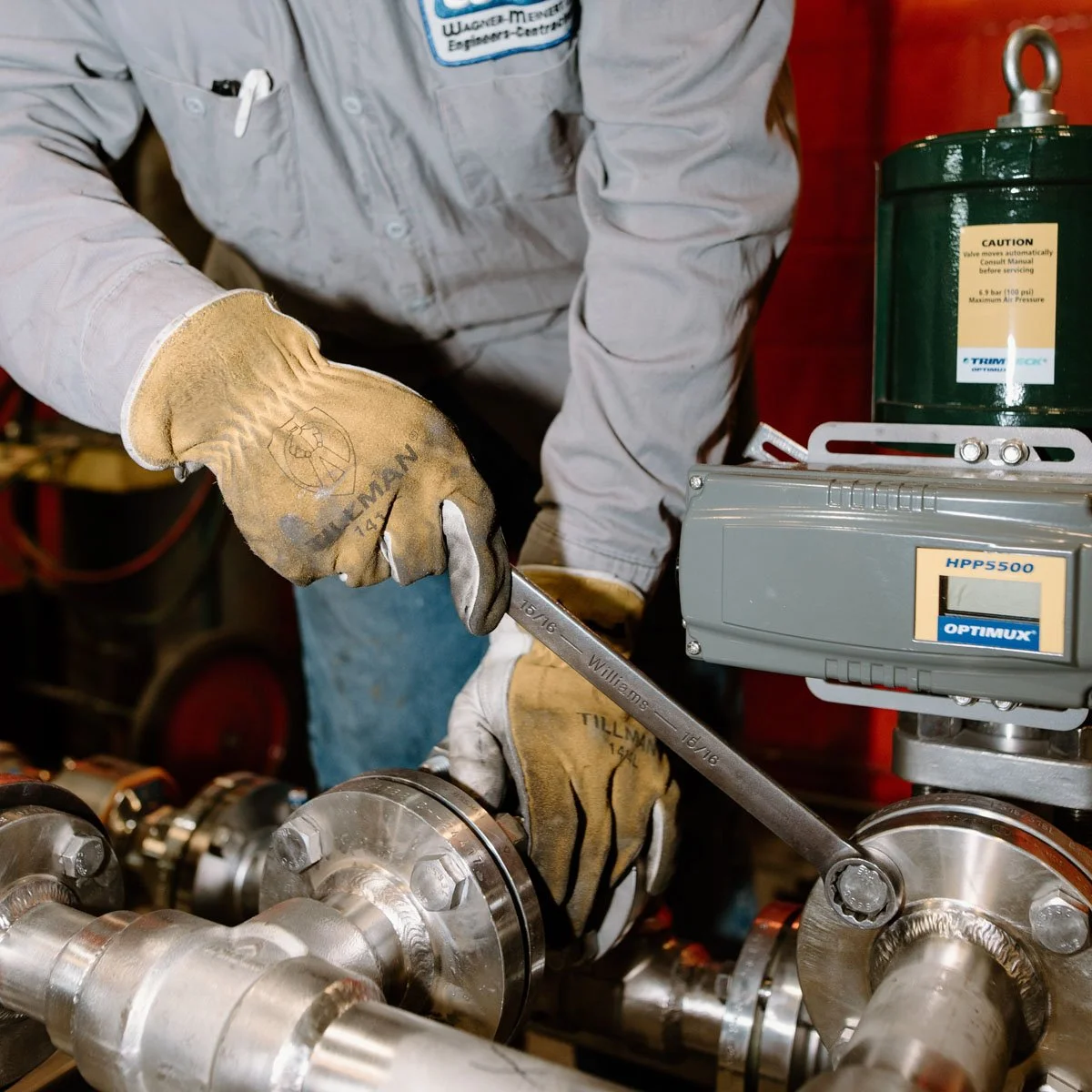 Employee using a wrench on an industrial part