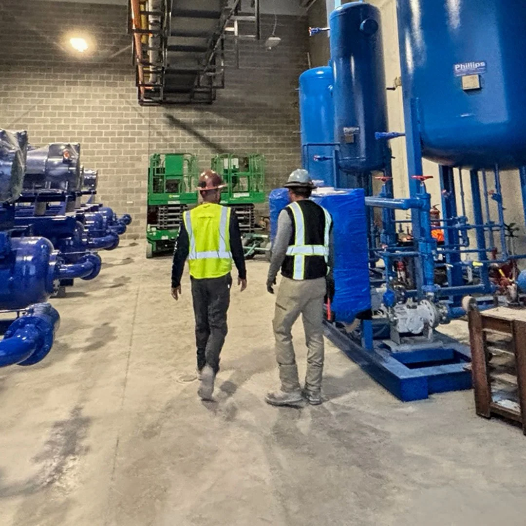 Two workers walking through systems room
