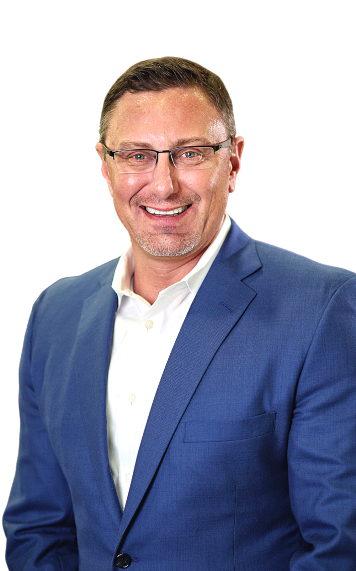 A smiling man with short brown hair, wearing glasses, a white shirt, and a blue suit, against a plain background.