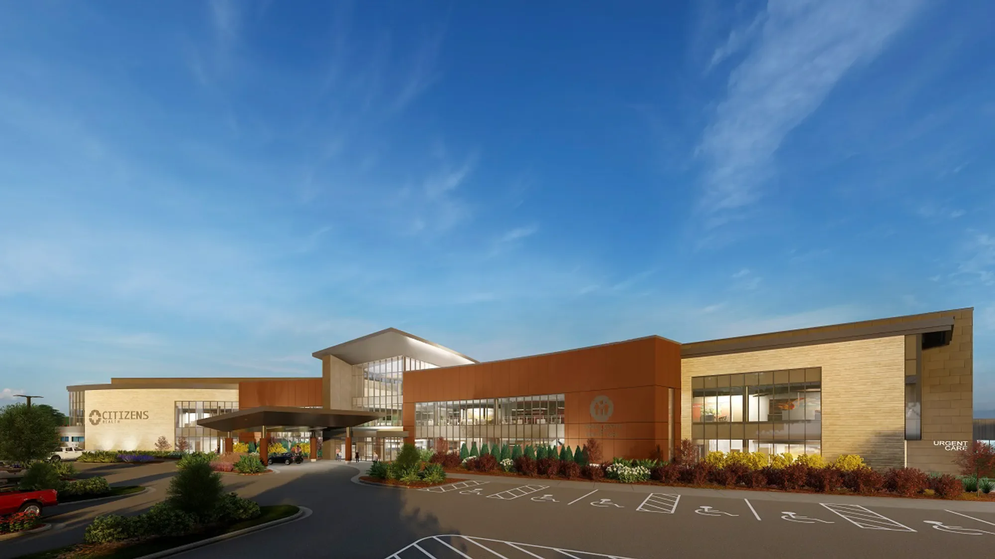 Modern medical building with the signage 'Citizens' and 'Urgent Care' visible outside, surrounded by landscaped parking lot with handicapped spaces and cars, under a clear blue sky.