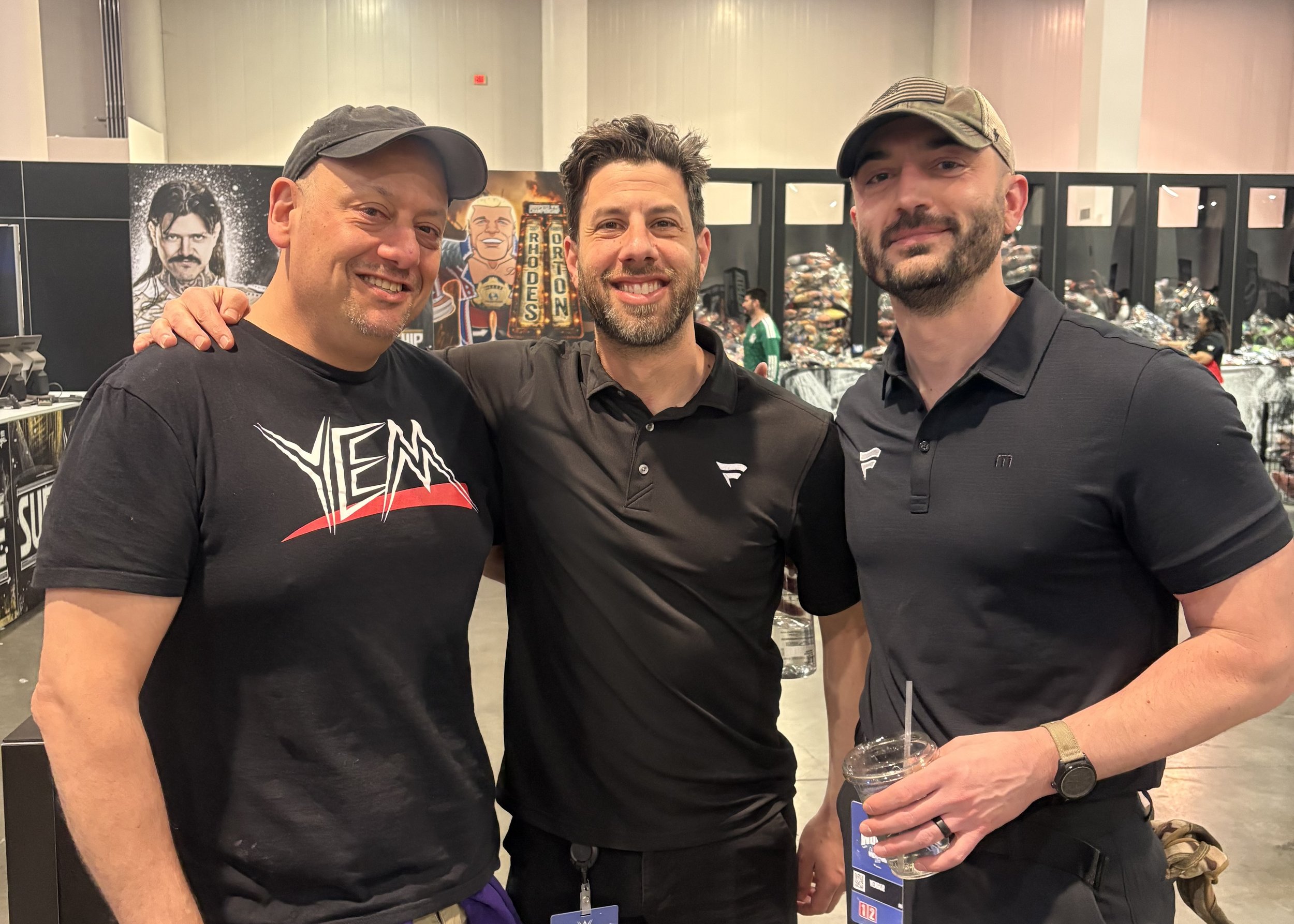 Three men stand in a line and pose for a photo