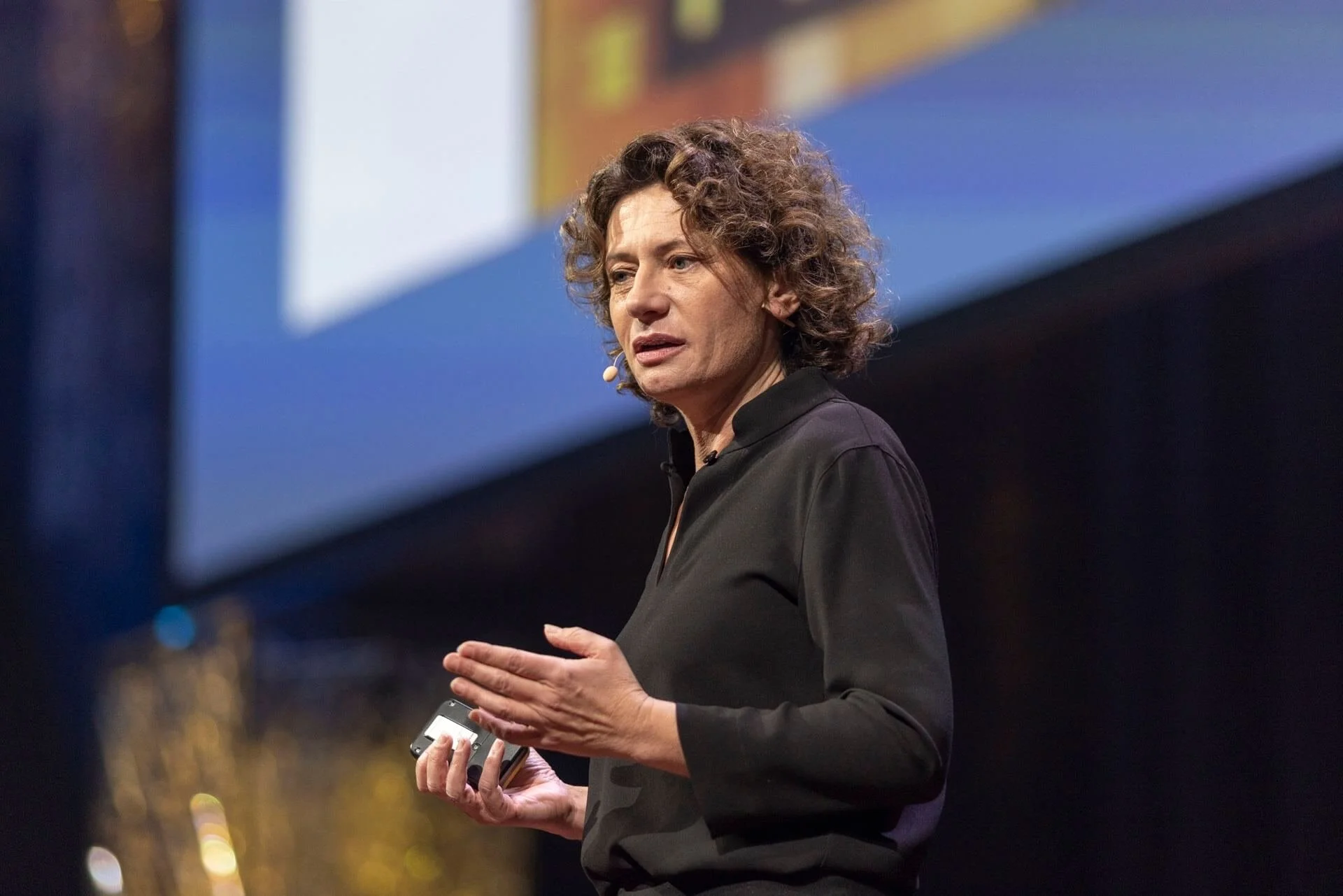 Andrea Belliger hält ein Mikrofon in der Hand und spricht vor einem Publikum.