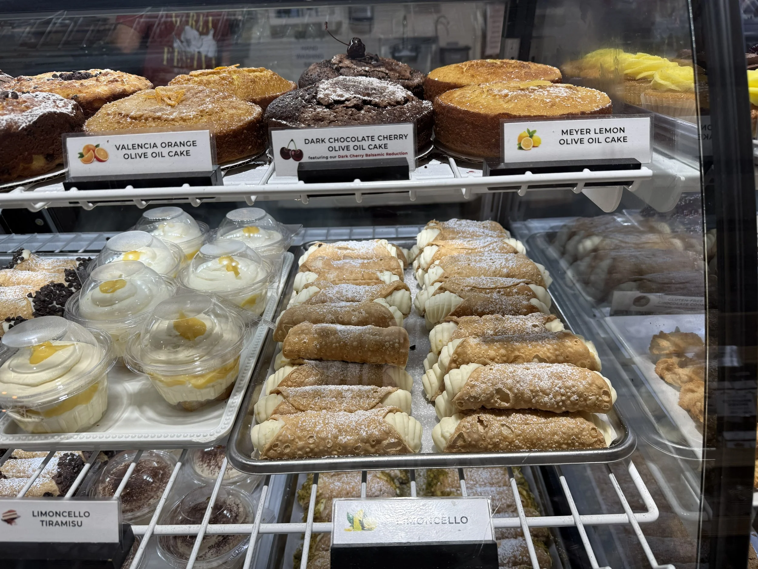 Bakery case filled with olive oil cakes, pastries and homemade limoncello cannoli.