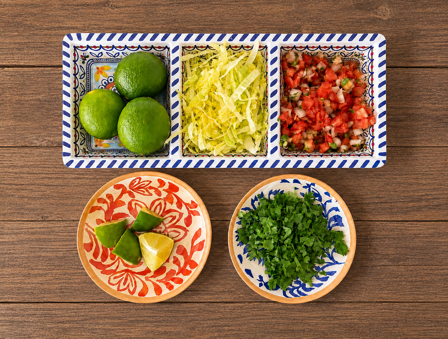 Overhead view of limes, shredded cabbage, pico de gallo, and chopped cilantro in small dishes