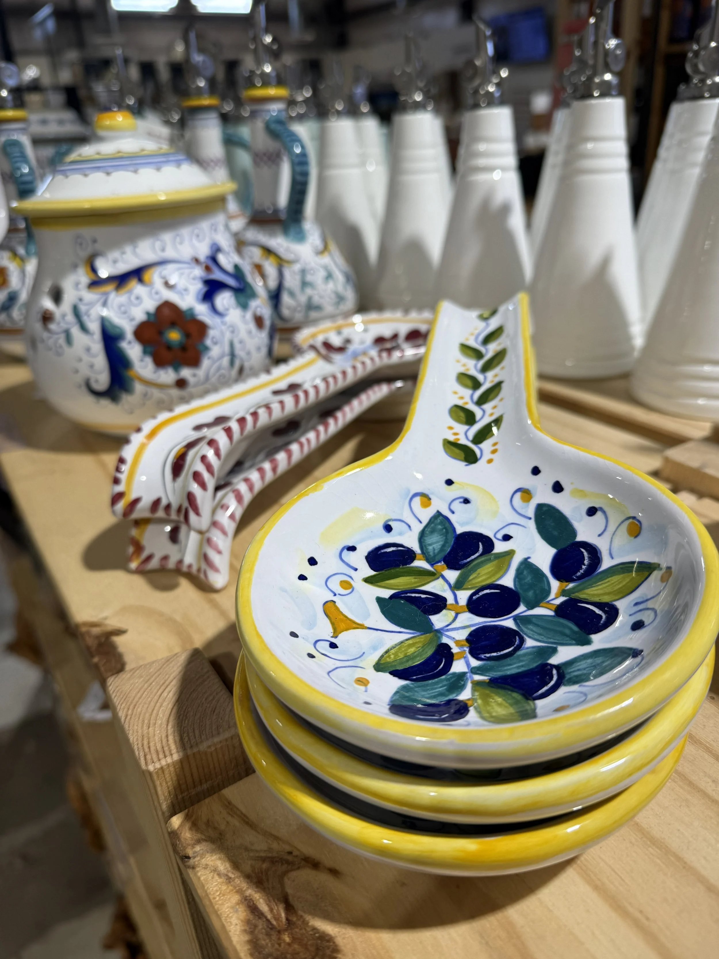 Colorful Italian ceramic spoon rests and olive oil dispensers displayed in the Queen Creek Olive Mill marketplace.
