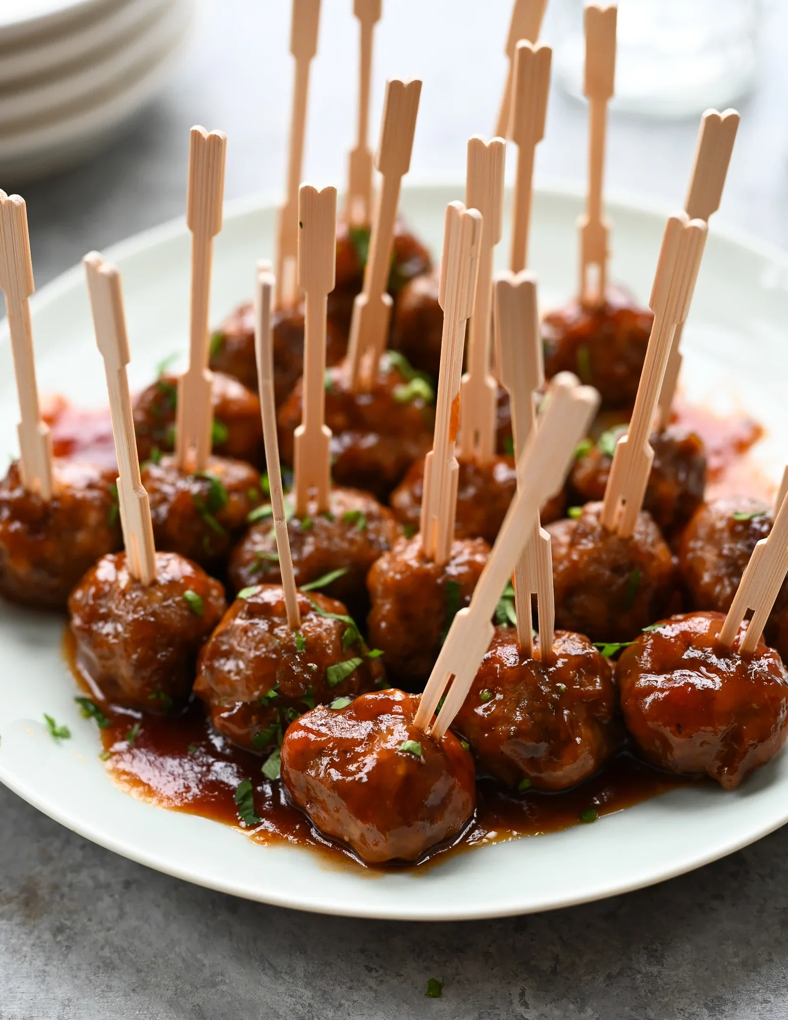 Cocktail meatballs in barbecue sauce served with wooden appetizer picks.