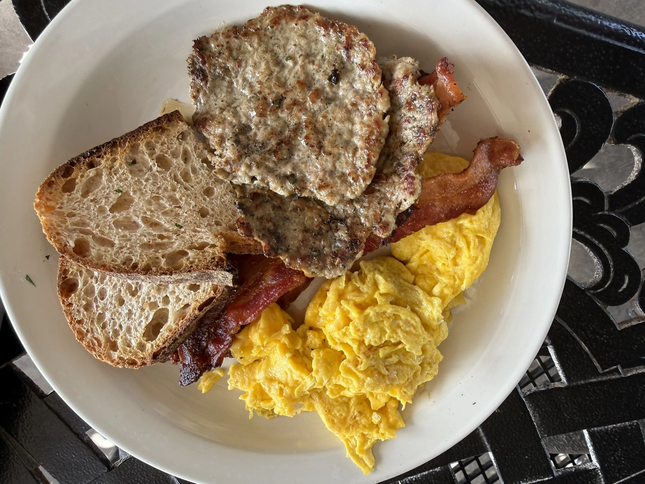 Breakfast plate with scrambled eggs, bacon, sausage patties and toast at Queen Creek Olive Mill.