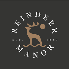 Reindeer Manor -logo, jossa poro ja kello, teksti 'Reindeer Manor' ja 'EST. 1843', mustalla taustalla.