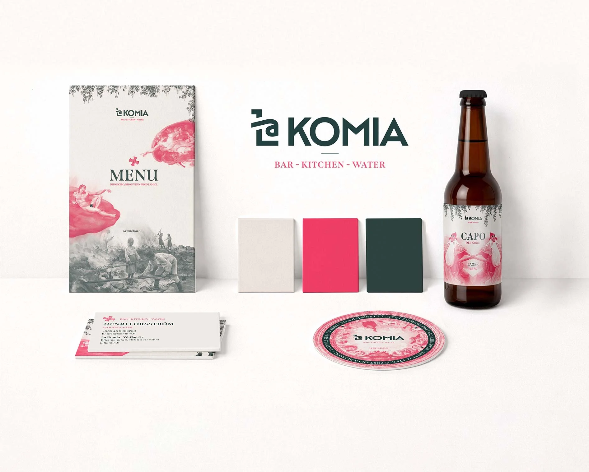 Näyttävä mainos tai esityskokonaisuus, jossa on muuta sisustusta, kuten valkoinen, pinkki ja tummanvihreä värivaihtoehdot, sekä olutpullo, kortti- ja käärepohja, juliste ja esite, kaikki brändin ’La Komia’ tuotteisiin liittyen.