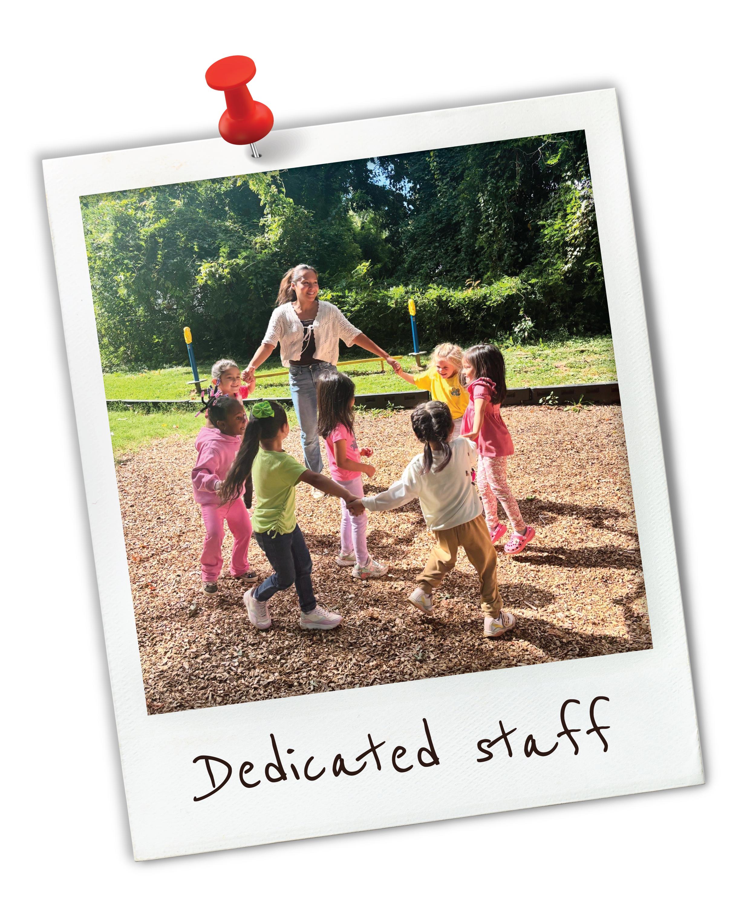 A group of children playing outdoor with a woman, holding hands in a circle, on grassy and wooded area, with the caption "Dedicated staff" underneath.