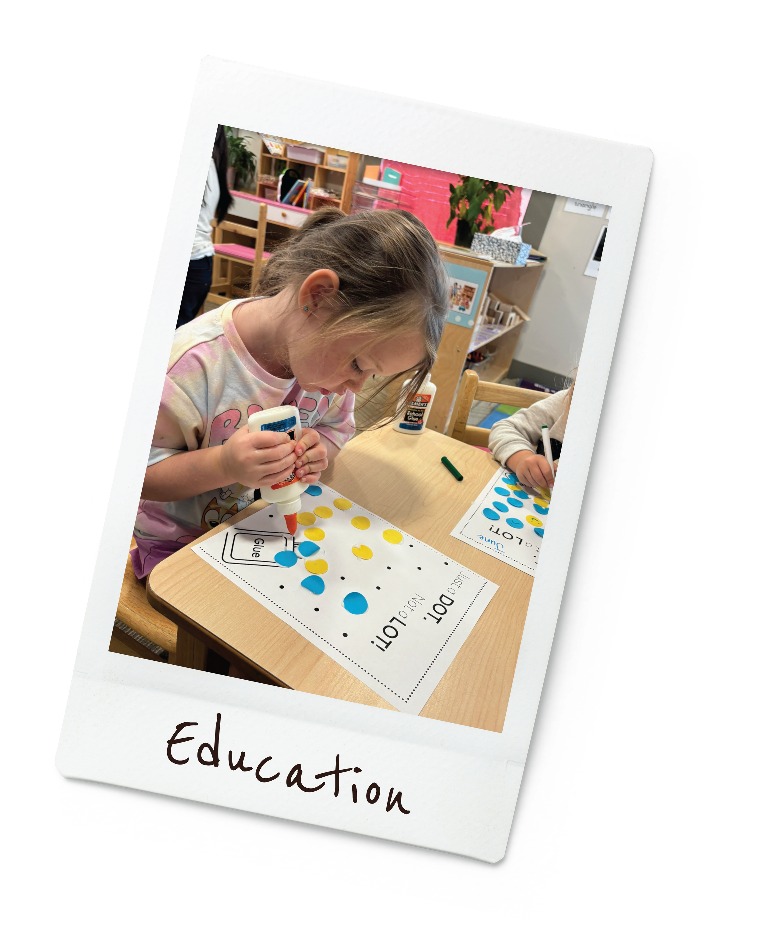 Child creating dot art with glue and colorful stickers in a classroom setting.